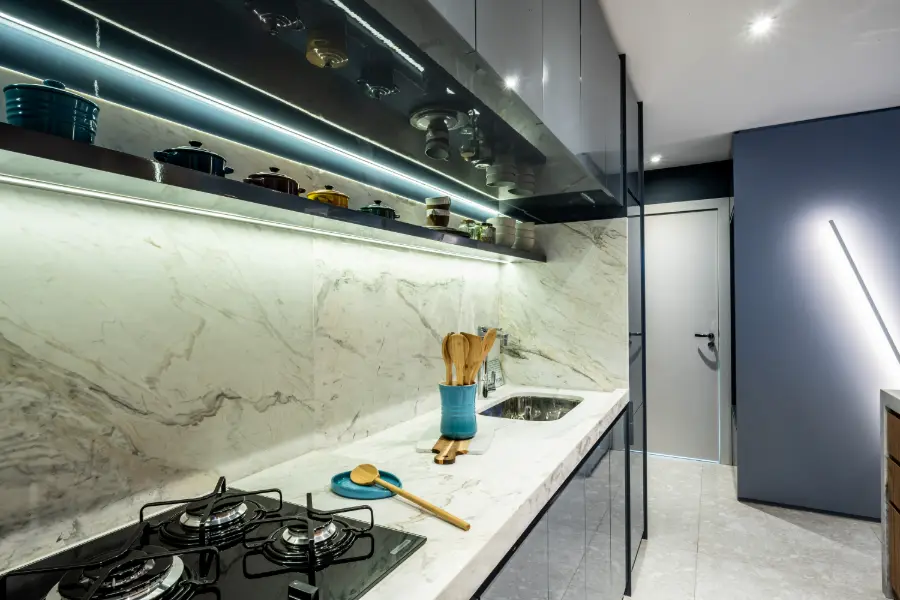 Detalhe da cozinha do decorado de 90 m² com bancada de pedra e cooktop